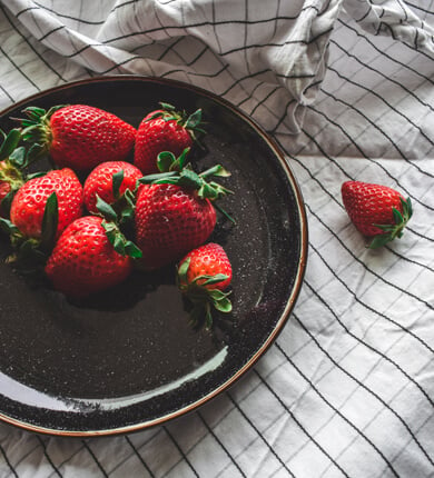 Fresh strawberries on a black plate